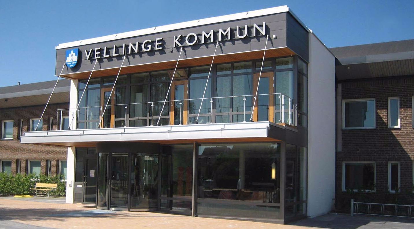 Kommunhuset i Vellinge kommun. En brun tegelbyggnad med en entré med svängdörr av glas.
